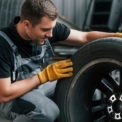 branche-dienstleistung-xs Mechaniker prüft einen Reifen