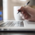 service-digitale-welten-xs Eine Person am Laptop in der Hand einen Stift
