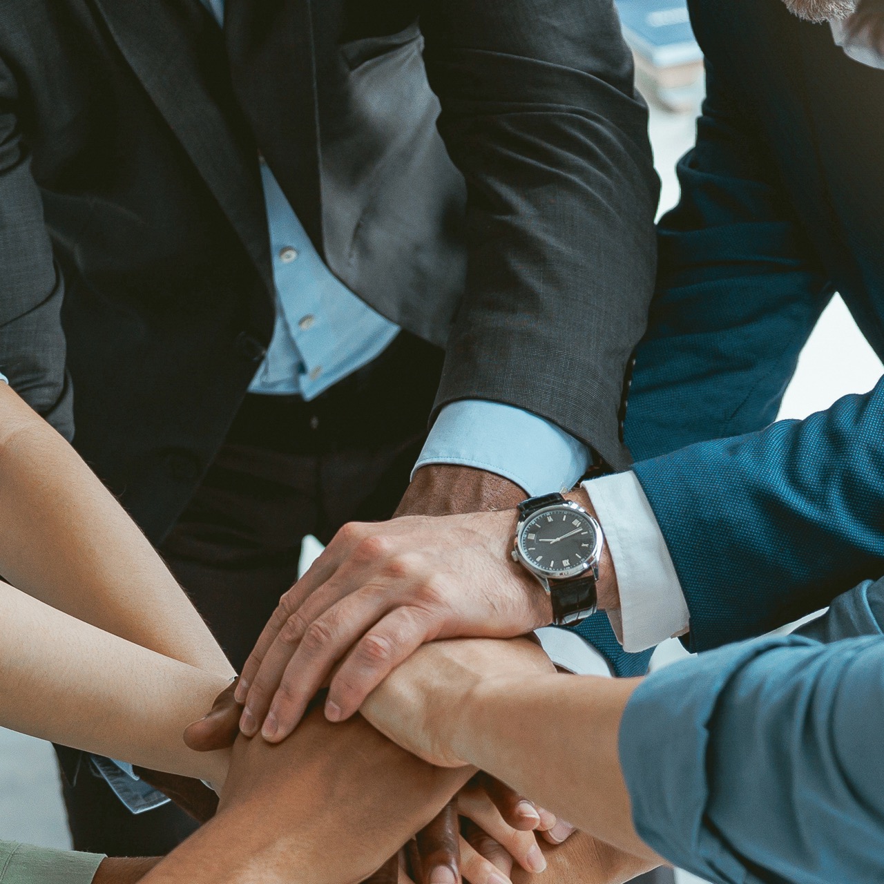 Gruppe von Mitarbeitern reicht sich die Hände